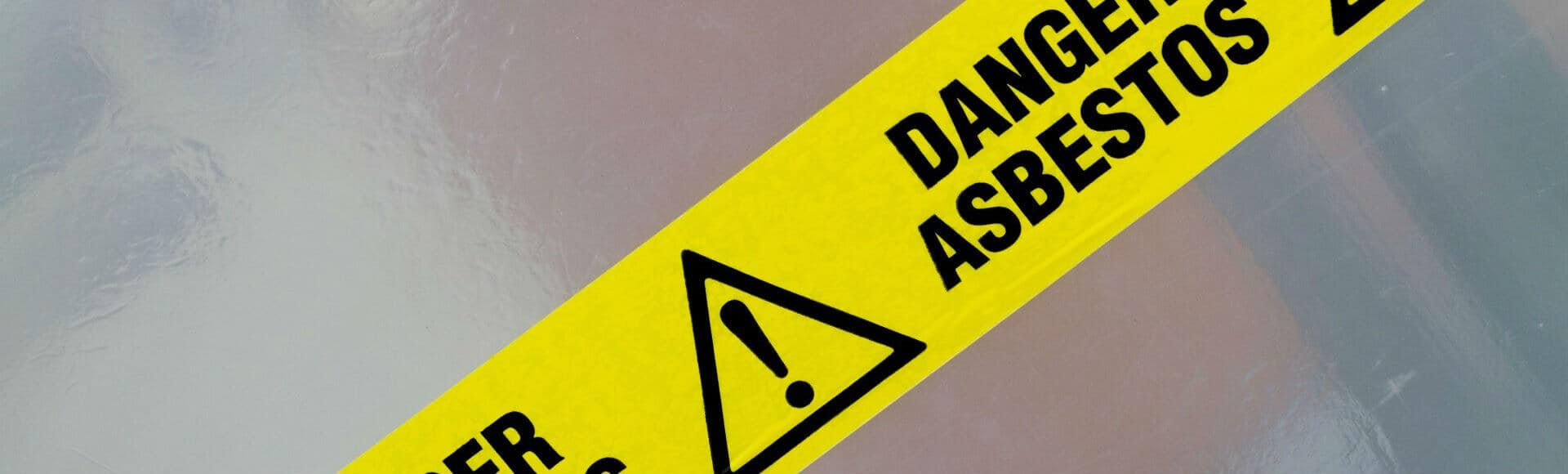 Danger Asbestos yellow warning tape close up